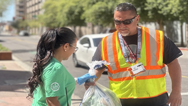 A Zero Waste ambassador and a Public Works employee work together to change a full waste collection bag during Final Four events in downtown Phoenix.